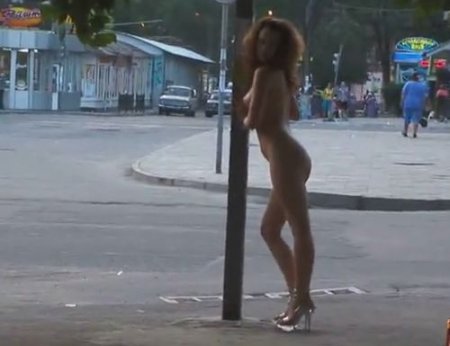 Городская нудистка без одежды гуляет по улице и позирует голой