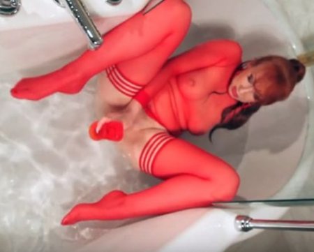 Ярко рыжая женщина балуется в душе с резиновым членом